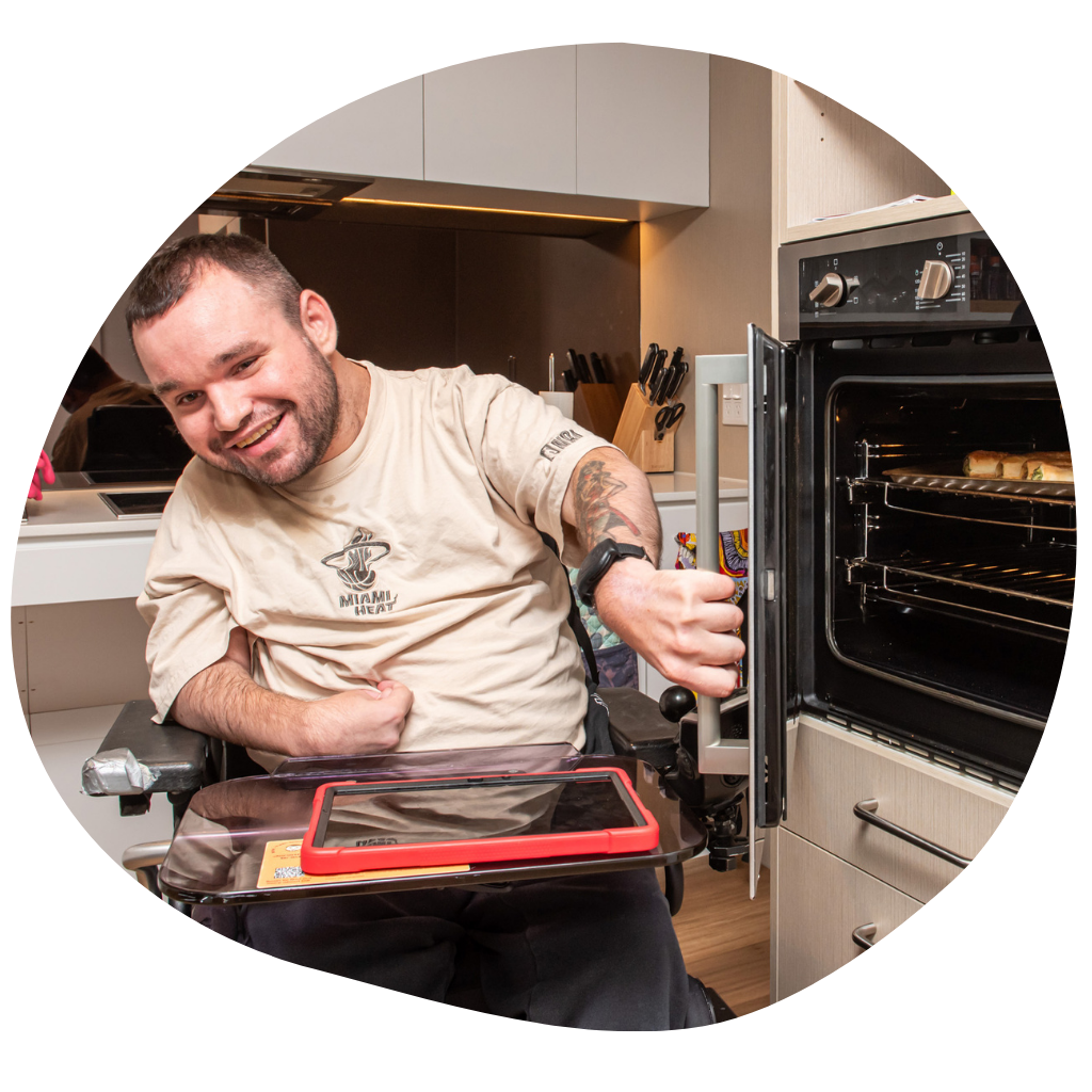 Jono opening the door to his oven to get sausage rolls out