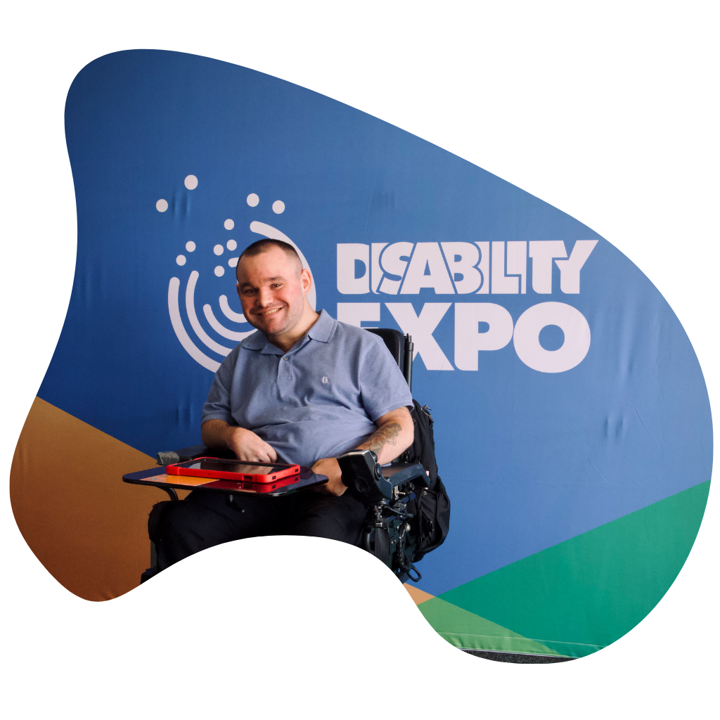 Jono posing in front of the Disability expo sign